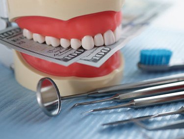 a model of teeth with cash between them