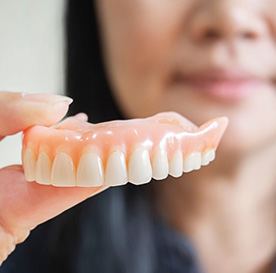 a person holding a set of dentures