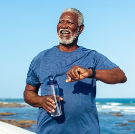 Senior man smiling while walking on beach path