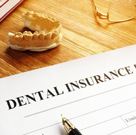 a dental insurance form next to wax teeth