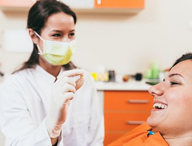 Dentist showing a patient her extracted tooth