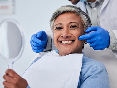 Patient smiling as dentist points to her teeth