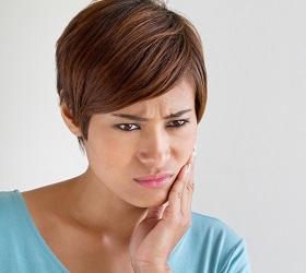Woman holding jaw in pain