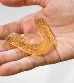Person holding custom mouthguard for protecting dental implants in Ridgefield