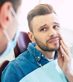 Man with oral pain visiting dentist for dental implant salvage in Ridgefield, CT 